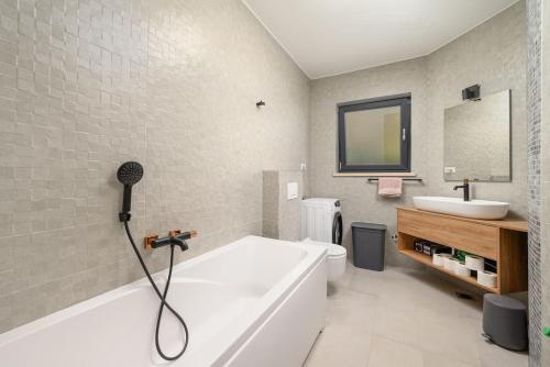 a bathroom with a bath tub and a sink at Villa Fierra by IstriaLux in Svetvinčenat