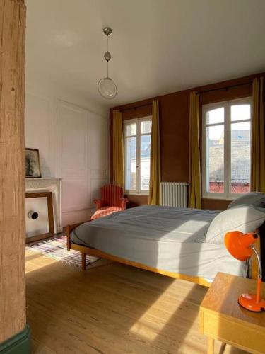 une chambre avec un grand lit et deux fenêtres dans l'établissement Maison familiale éco rénovée, à Ault