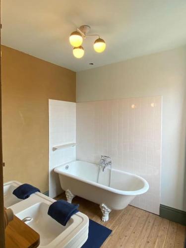 La salle de bains est pourvue d'une grande baignoire et d'un lavabo. dans l'établissement Maison familiale éco rénovée, à Ault