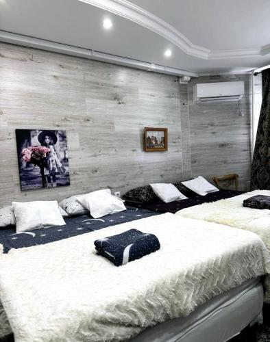 twee bedden in een slaapkamer met een muur bij Smart Apartment in Chişinău