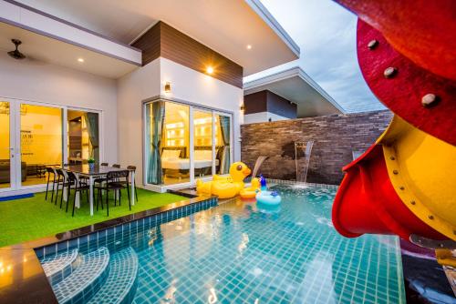 a pool with a slide in a house at Cocomelon Poolvilla1 in Hua Hin