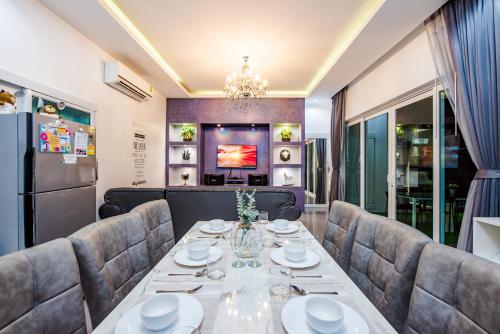 a dining room with a long table and chairs at Cocomelon Poolvilla1 in Hua Hin