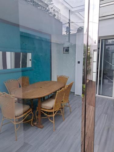 - une salle à manger avec une table et des chaises en bois dans l'établissement Villa de ville, à Rabat