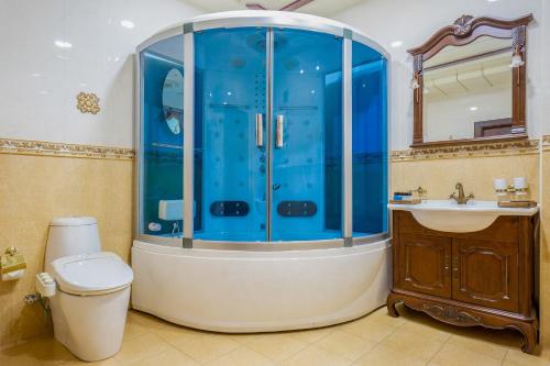 a bathroom with a shower and a toilet and a sink at Darhan Boutique Hotel in Tashkent