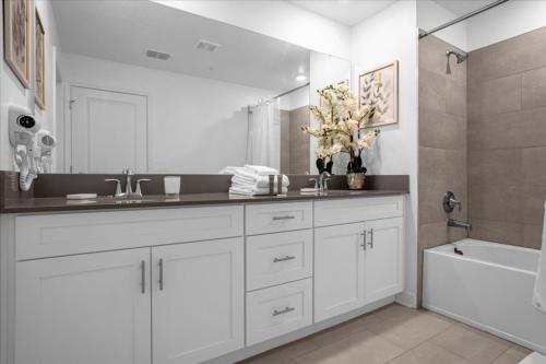Baño blanco con lavabo y bañera en 5 Bedrooms- 4 Bathrooms- Storey Lake 2432rt New, en Kissimmee