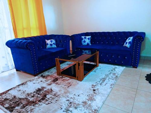 a living room with two blue couches and a coffee table at Bamburi 2 bedroom Luxury homes in Bamburi