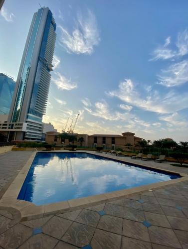 a swimming pool in front of a tall building at the971stay in Dubai