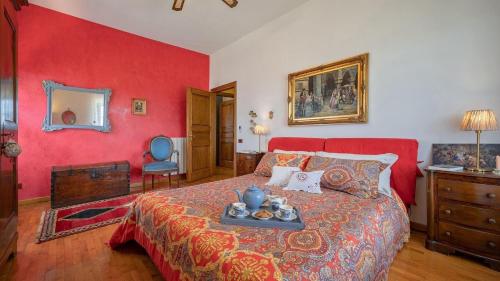 um quarto vermelho com uma cama com uma bandeja em Bellosguardo 8 em Castellina in Chianti