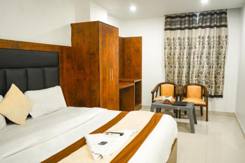 a bedroom with a bed and a table and chairs at Hotel Vandana stay sec-08 in New Delhi