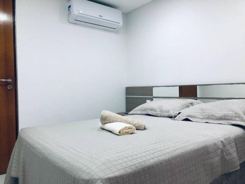 un perro acostado en una cama en un dormitorio en Lugar Aconchegante e Central a 1.200mts do Busto de Tamandaré en João Pessoa