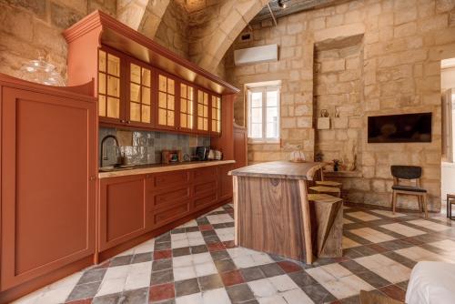 a kitchen with a wooden island in a room at Talbot House by Talbot & Bons in Luqa