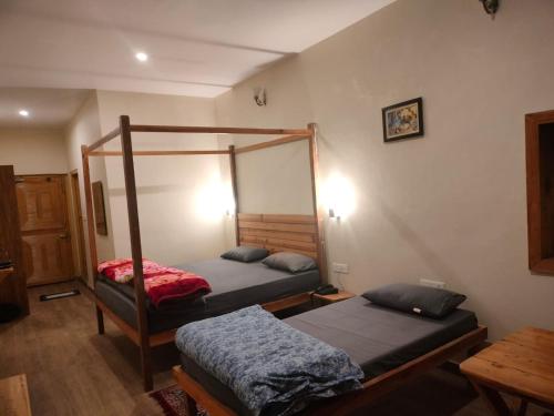 1 dormitorio con 2 literas y mesa en Kross Vindz, en Mukteshwar