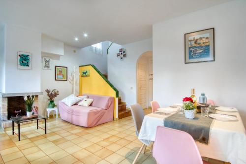 een woonkamer met een tafel en een roze bank bij Palshaus in Pals