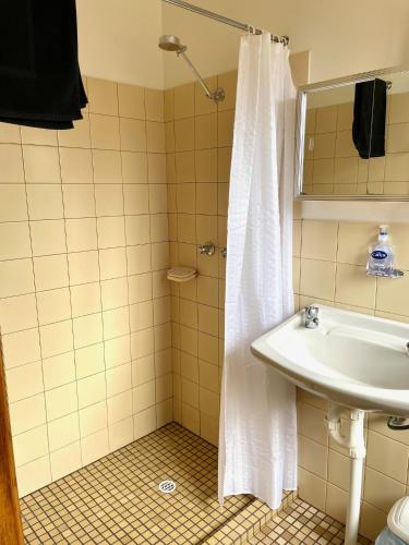 a bathroom with a white shower curtain and a sink at Cooinda Holiday Village Cabins in American River