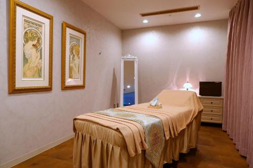 a bedroom with a bed and a dresser and a television at Sheraton Grande Tokyo Bay Hotel in Urayasu