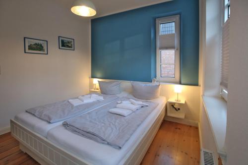 een slaapkamer met een bed met handdoeken erop bij Badestra_e 94_ Whg_ 2_ Haus am Wal in Wyk auf Föhr