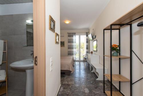 un corridoio con lavandino e un bagno con letto di Tsolakis Studios & Apartments a Laganas