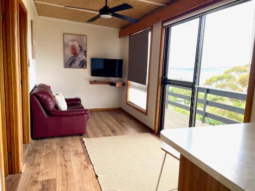 a living room with a couch and a flat screen tv at Cooinda Holiday Village Cabins in American River