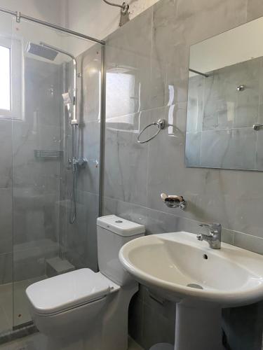 a white bathroom with a toilet and a sink at Vila M Vera Studios and Apartments in Durrës