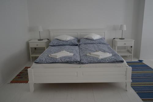 a white bedroom with a bed with two pillows at Vértessy ház in Keszthely