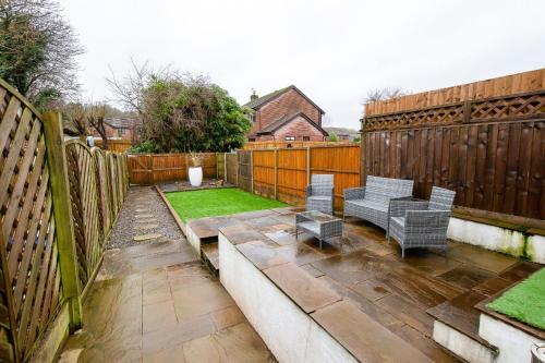 a patio with two chairs and a fence at Casa One Hundred - A Beautiful 4 Bed House on the Beach Front in Swansea