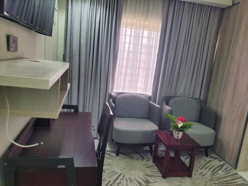 a small room with two chairs and a table and a window at Lovely 1 bedroom self catering apartment in Lusaka