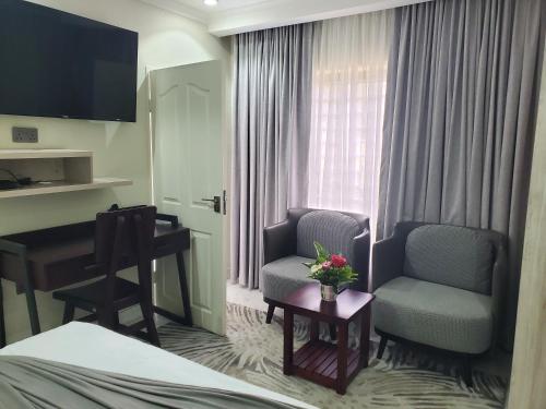 a hotel room with a bed and a chair and a desk at Lovely 1 bedroom self catering apartment in Lusaka