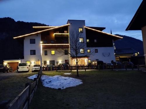 a large white building with snow in front of it at Appartementhaus Hüttenberger in Erpfendorf