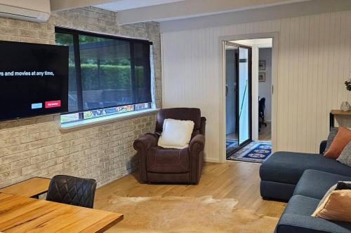 a living room with a chair and a tv at Perfect Country Home in Tawonga