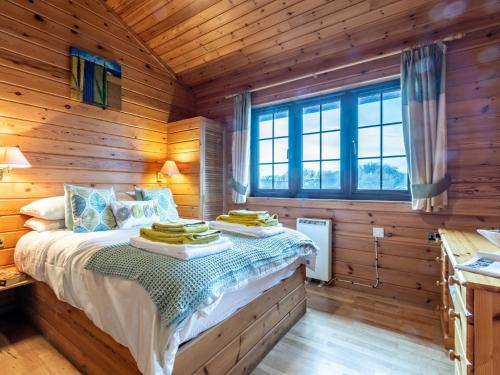 a bedroom with a bed in a log cabin at 2 Bed in Clovelly 00357 in Clovelly