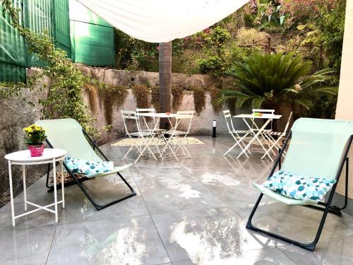 eine Terrasse mit 2 Stühlen und Tischen mit Pflanzen in der Unterkunft Case Costy in Aci Castello