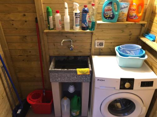 eine Küche mit einer Spüle und einer Waschmaschine in der Unterkunft Case Costy in Aci Castello