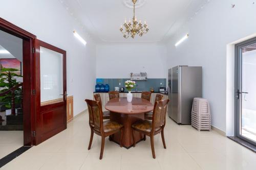 Un comedor con una mesa y un refrigerador. en Villa Hồ Bơi Bãi Sau - Free Loa Kéo + Bida - Gần Biển - 10/11B LLQ, en Vung Tau