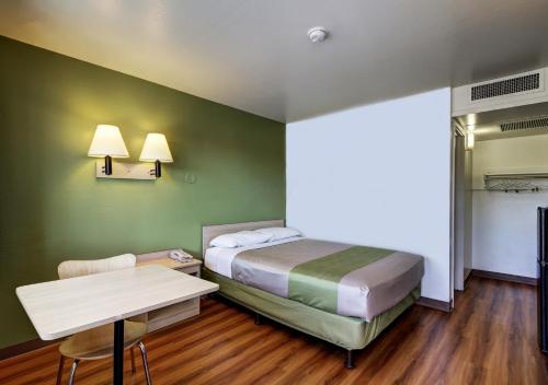 a bedroom with a bed and a table and a desk at Econo Lodge Midvale in Midvale