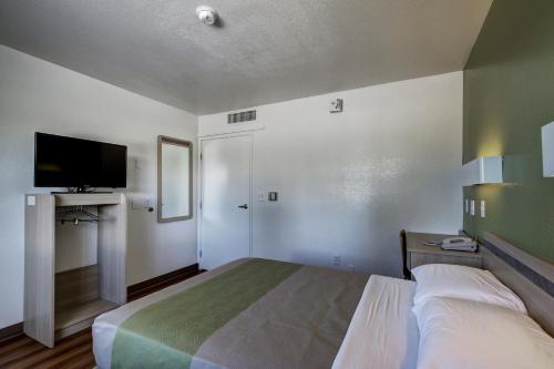 a bedroom with a bed and a flat screen tv at Econo Lodge Midvale in Midvale