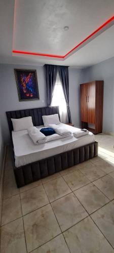 a large bed in a room with a window at De Miami Park Suites & Bar in Owerri