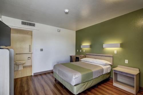 a small bedroom with a bed and a bathroom at Econo Lodge Midvale in Midvale