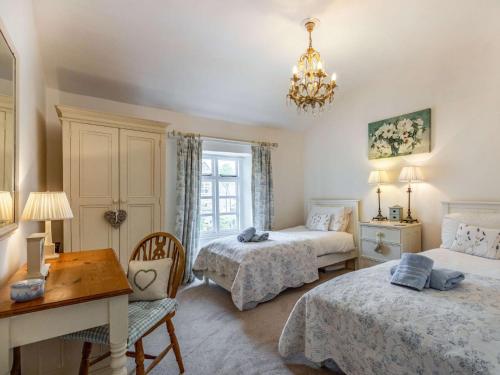 a bedroom with two beds and a table and a desk at 2 Bed in Bourton-on-the-Water 29027 in Bourton on the Water