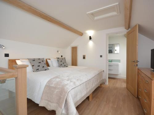 a bedroom with a white bed and a wooden floor at 1 Bed in Curry Rivel 41489 in Curry Rivel