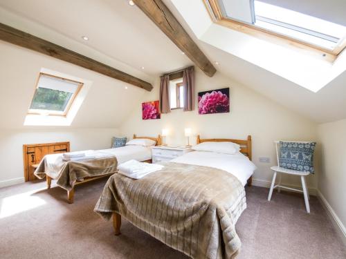 Barlowにある2 Bed in Baslow PK801の天窓付きの屋根裏部屋のベッドルームにベッド2台が備わります。