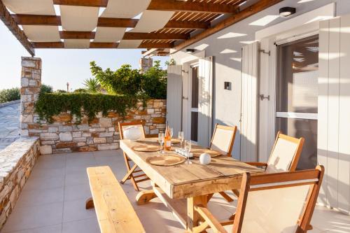 a wooden table and chairs on a patio at Mont' Rock villas 3 in Posidhonía
