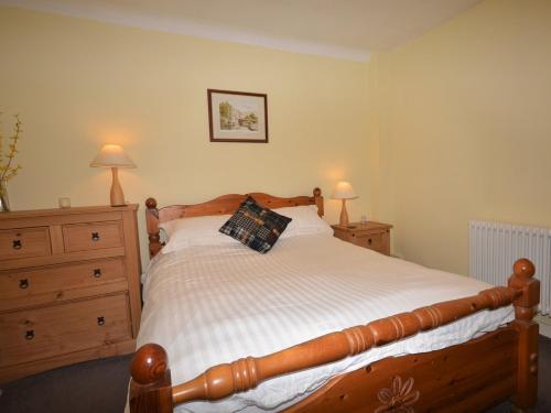 a bedroom with a wooden bed and two dressers at 1 Bed in Ballantrae 45713 in Ballantrae
