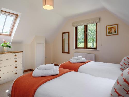 2 Betten in einem Schlafzimmer mit weißen Wänden und Fenstern in der Unterkunft 2 Bed in Sidmouth 50004 in Sidbury
