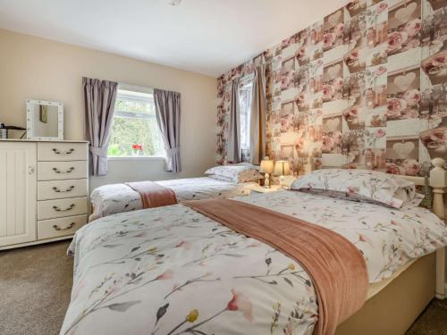 - 2 lits dans une chambre avec papier peint floral dans l'établissement 2 Bed in Cockermouth 49197, à Cockermouth