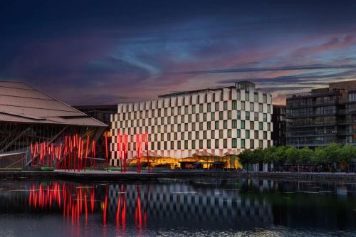 a large white building next to a body of water at Anantara The Marker Dublin- A Leading Hotel of the World in Dublin