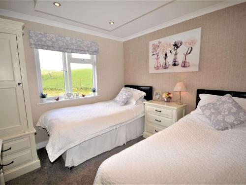 a bedroom with two beds and a window at 2 Bed in Lochwinnoch 55854 in Kilmacolm