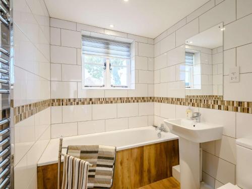 a bathroom with a bath tub and a sink at 2 Bed in Fordingbridge 56823 in Woodgreen