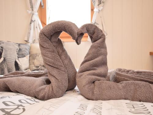 two towels in the shape of a heart on a bed at 1 Bed in Thetford 57900 in East Harling