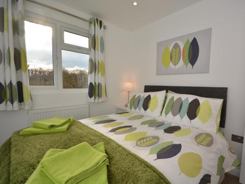 Un dormitorio con una cama con sábanas verdes y una ventana en 3 Bed in Moorlinch 56284, en Greinton