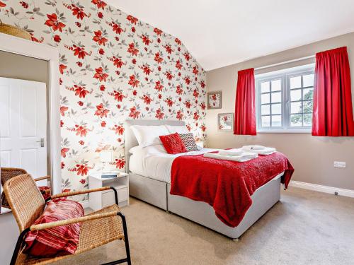 a bedroom with a bed with a red floral wallpaper at 4 Bed in Wedmore 58843 in Theale